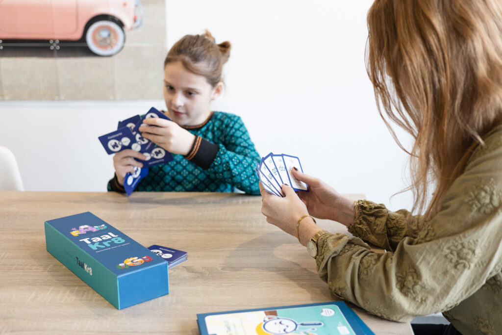 Kind oefent met doos vol taalkr8