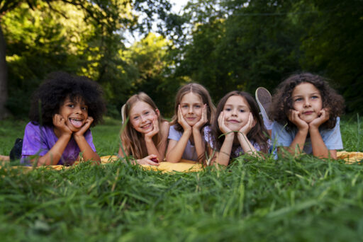 Kinderen liggen buiten in het gras